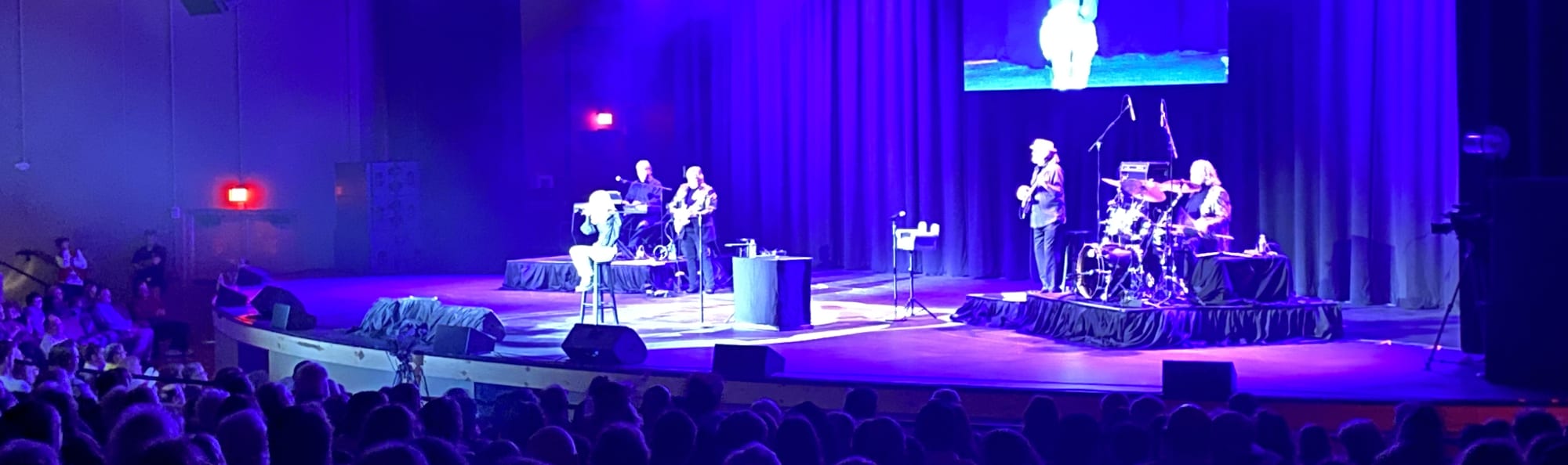 signer on stage in chair washed out by the lights Milwaukee